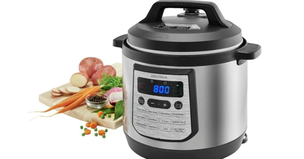 Insignia 6 quart pressure cooker with vegetables next to it