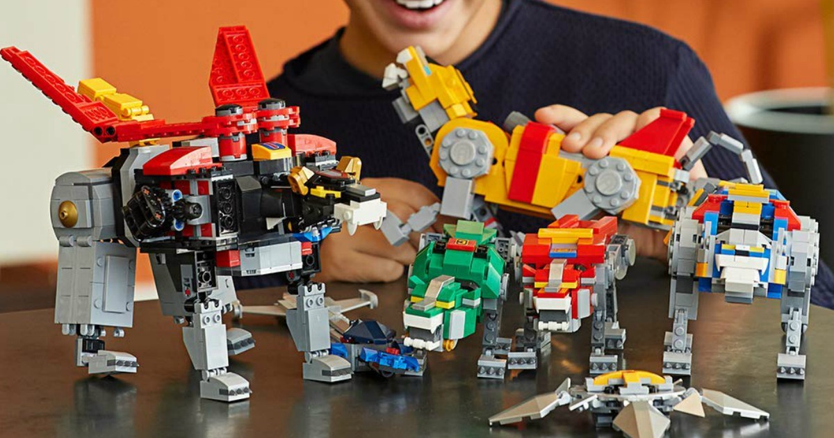Teenage boy playing with a LEGO set of Voltron 