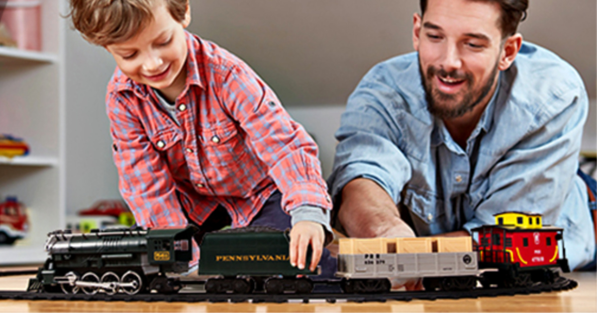 man and boy playing with lionel train set