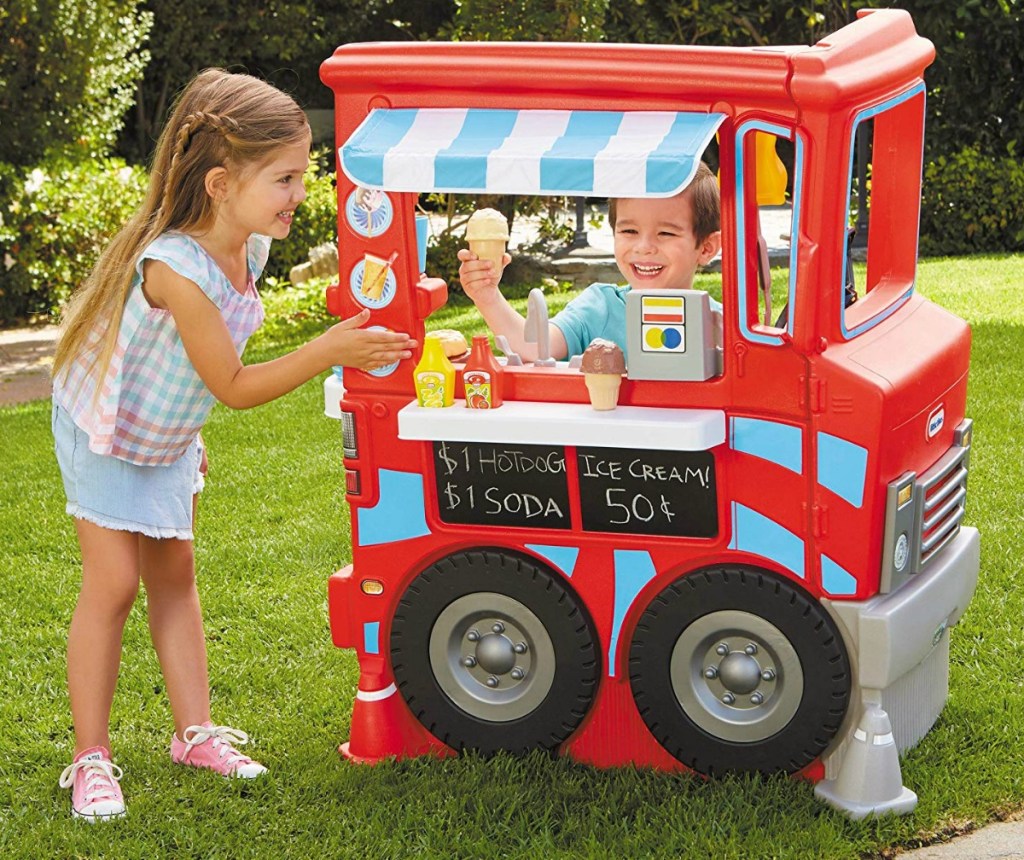 Kids playing with a Little Tikes 2-in-1 food truck outside