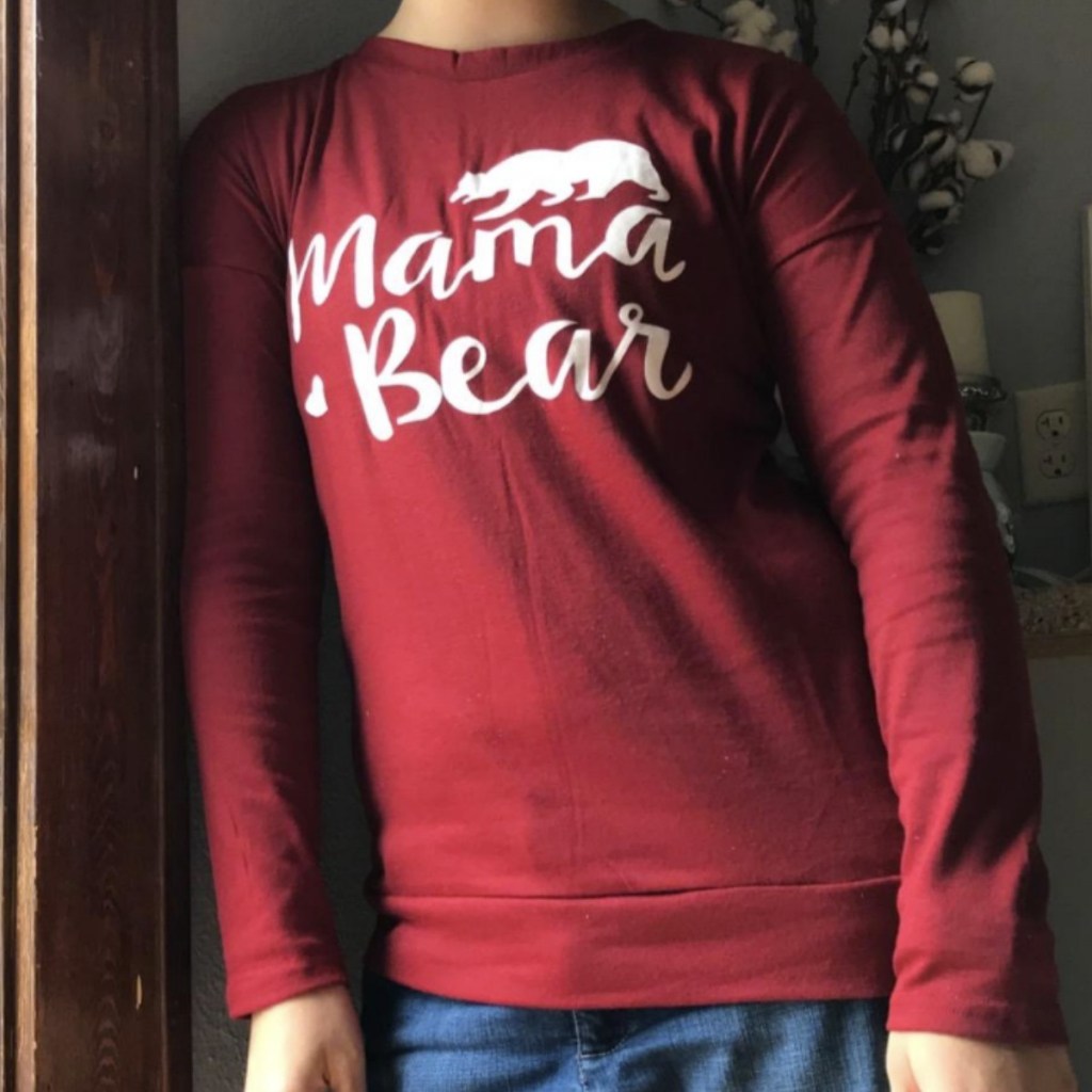 Woman wearing long sleeve shirt with Mama Bear phrase printed