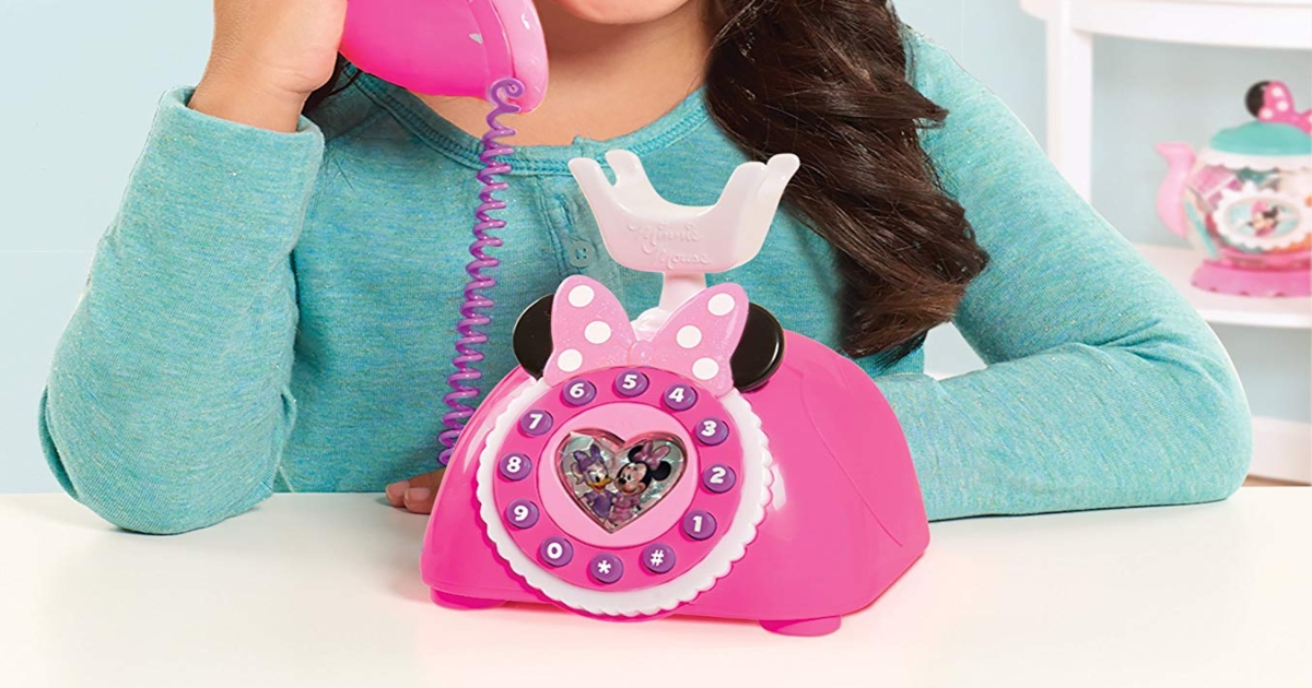 Girl in teal shirt answering a pink Minnie Mouse Phone