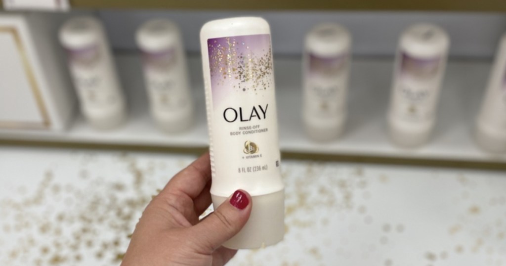 Hand holding Olay RinseOff Body Conditioner at Target
