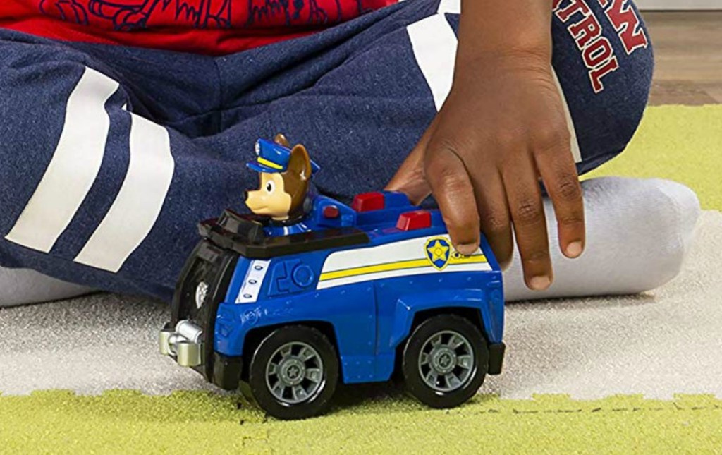 Boy playing with a Paw Patrol police vehicle and figure