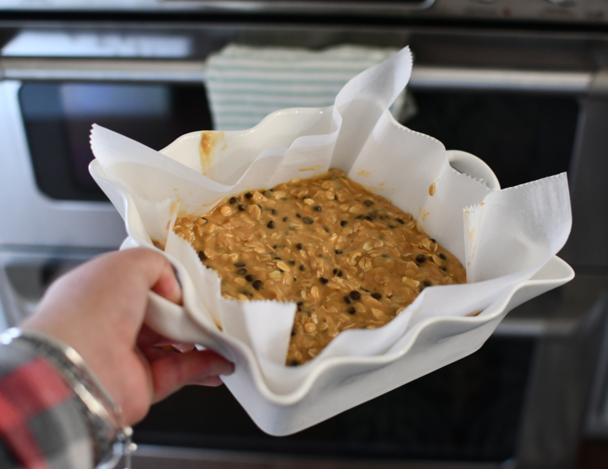 placing a pan of chocolate chip oatmeal bars into the oven to bake