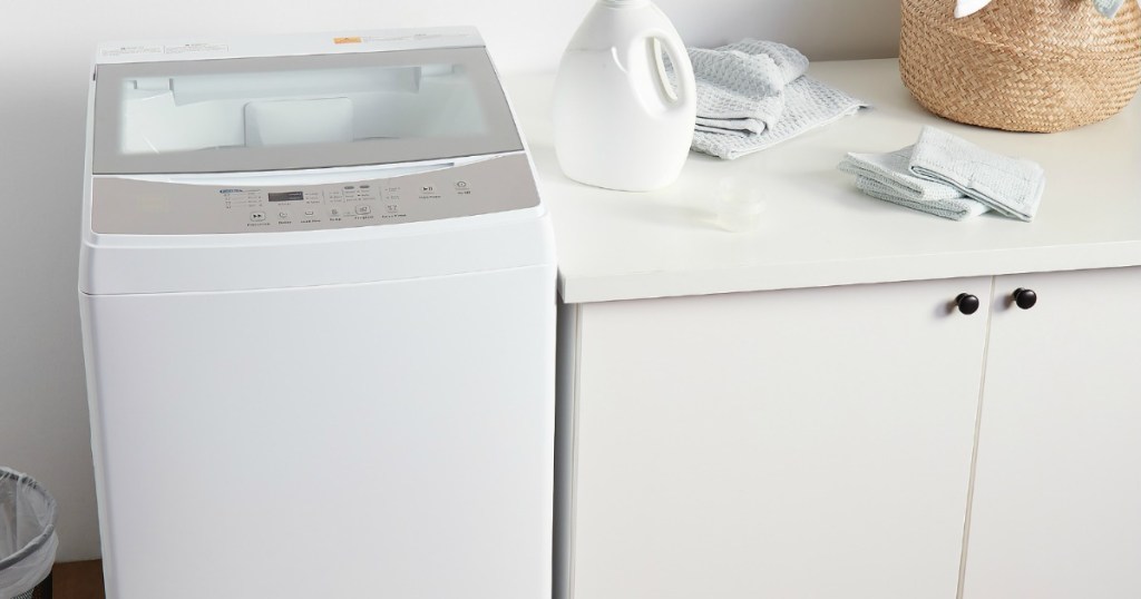 small washing machine next to a cabinet