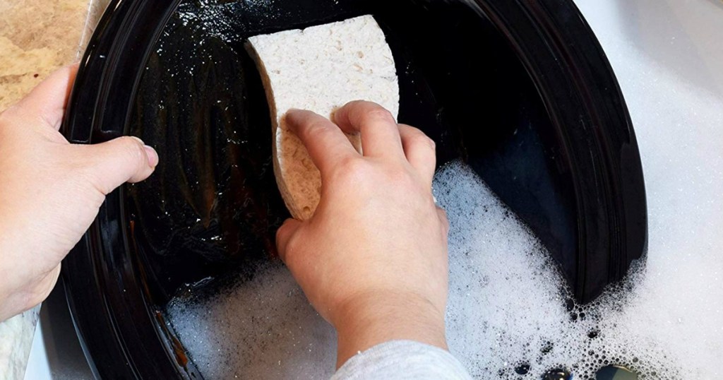 person washing dishes with a sponge