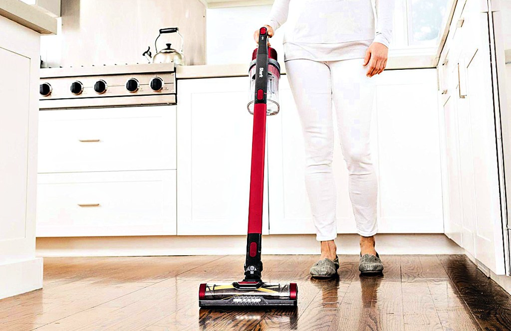 Shark Rocket Pet Pro Lightweight Cordless Stick Hand Vacuum with Self-Cleaning Brushroll being used by woman in kitchen
