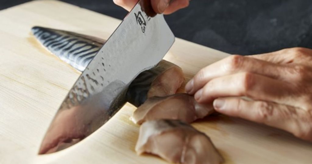 Shun Premier Chef's Knife cutting fish on cutting board