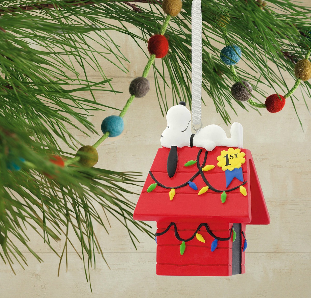 Peanuts Snoopy laying on dog house ornament hanging on tree