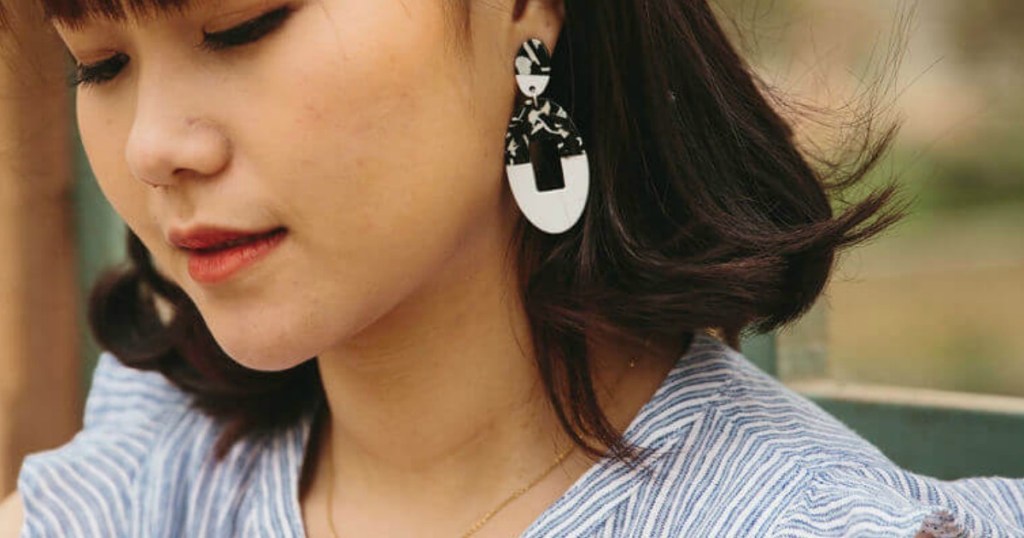 Woman with dark hair wearing Starfish Project dangling earrings