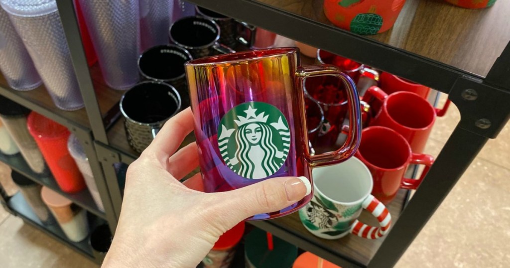woman holding pink and orange Starbucks mug
