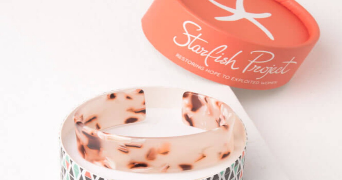 Starfish Project Cuff in round case, with orange lid off to the right side