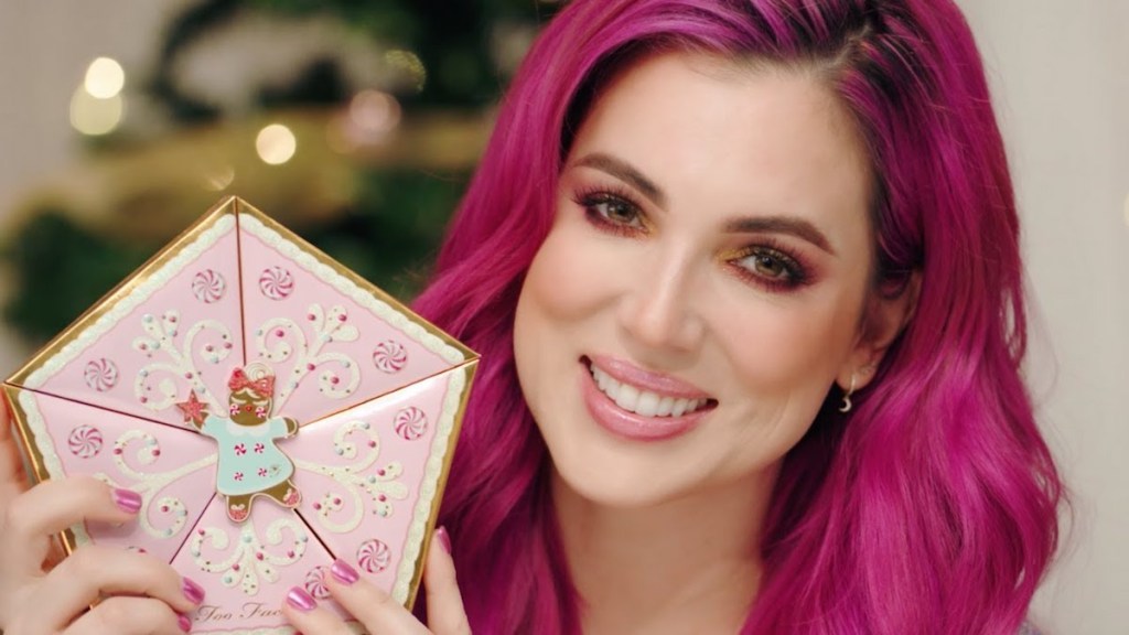 woman holding Too Faced Limited Edition Christmas Star Makeup Collections