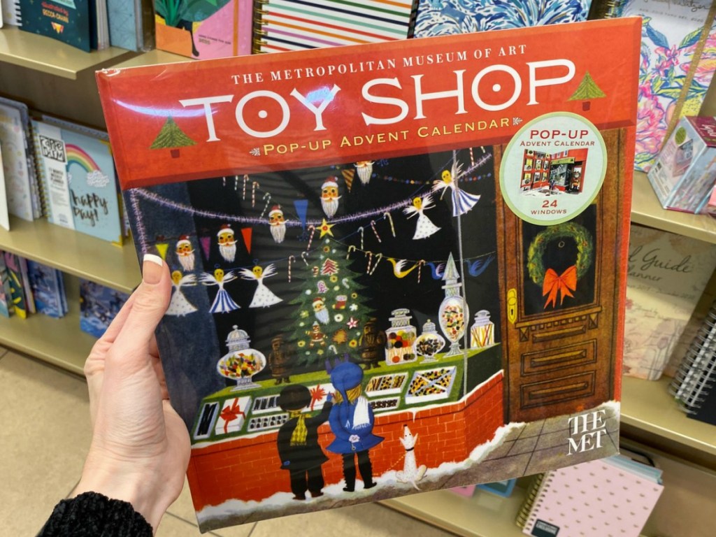Toy shop advent calendar in hand near in-store display