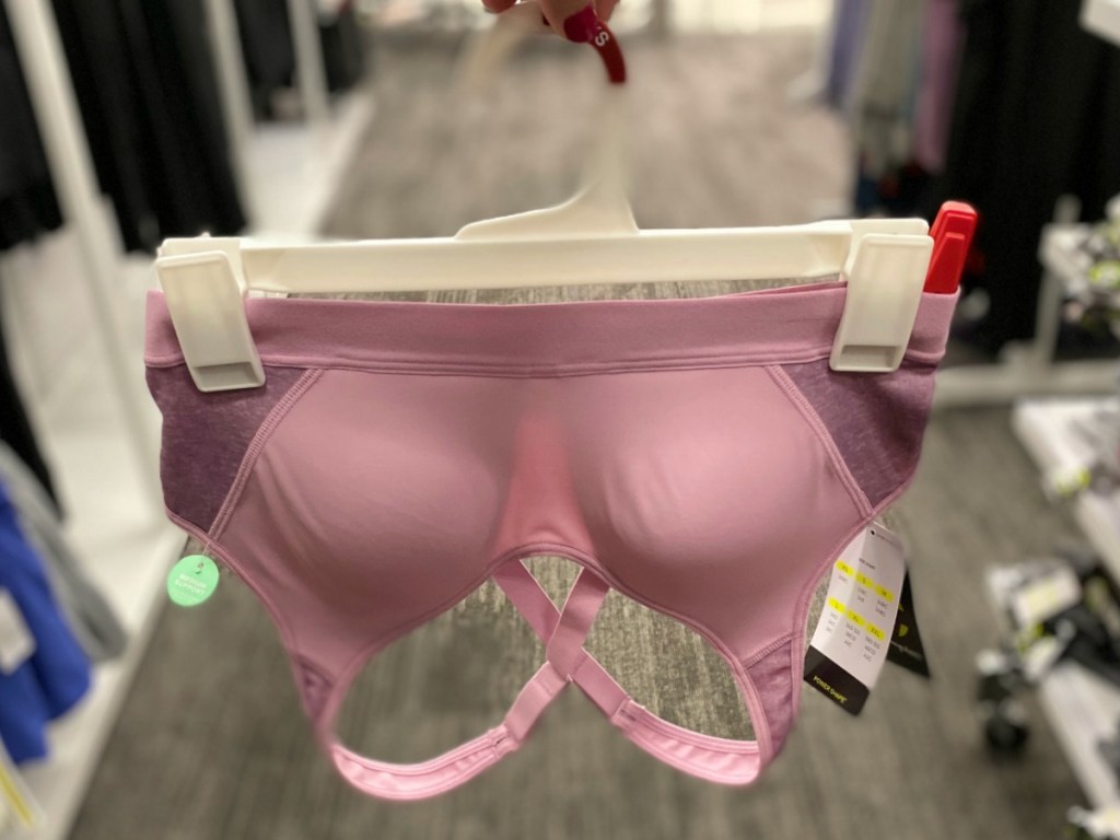 Women's pink sports bra on hanger in store in hand at Target