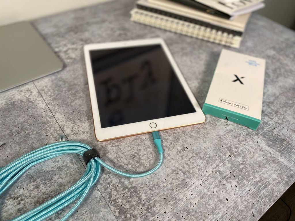 Xcentz Charging Cord Blue plugged into ipad on counter with box