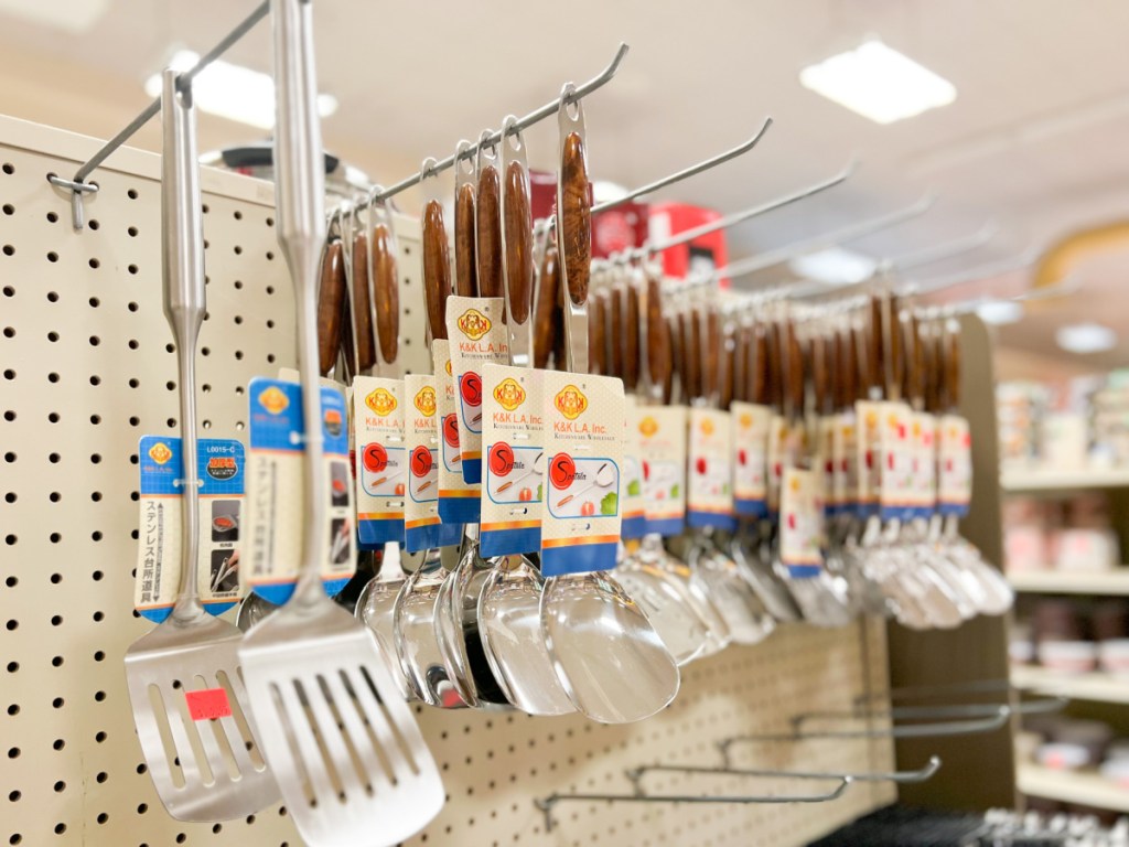 spatulas hanging on shelf at asian grocery store