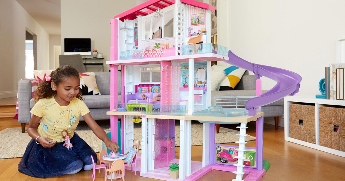 little girl playing with barbie dream house 