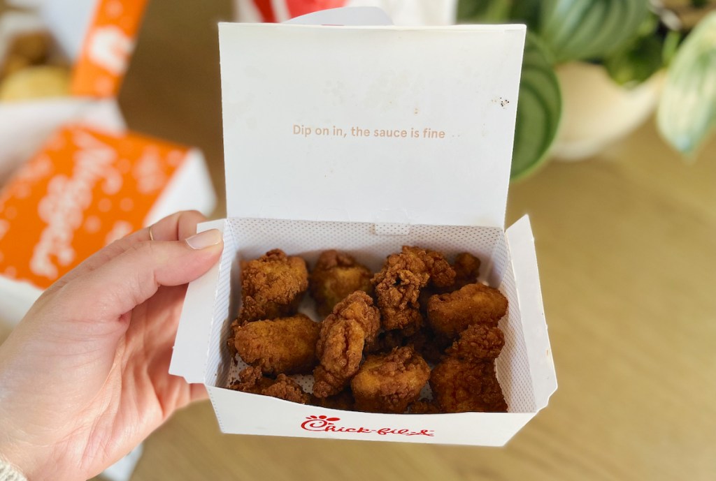 hand holding a box of chick fil a nuggets