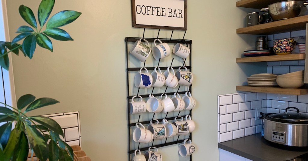 wall with coffee bar sign and metal wire mug rack and coffee mugs