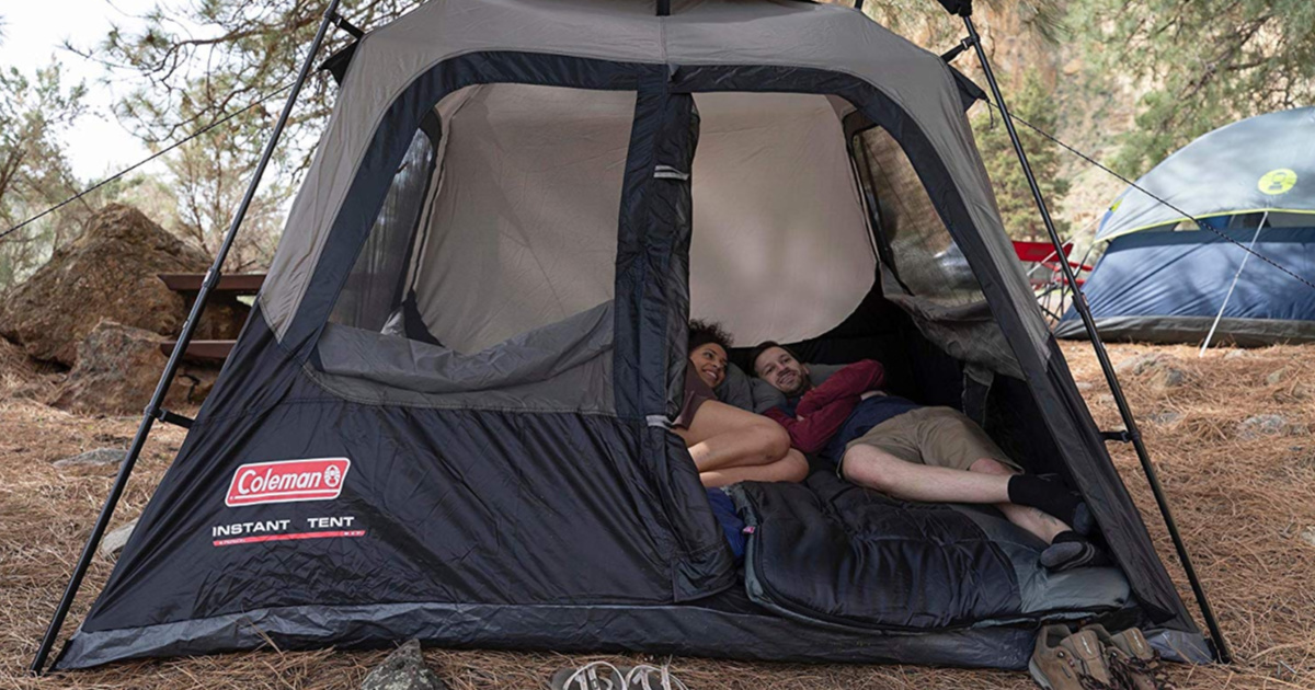 man and woman sleeping in coleman tent out doors