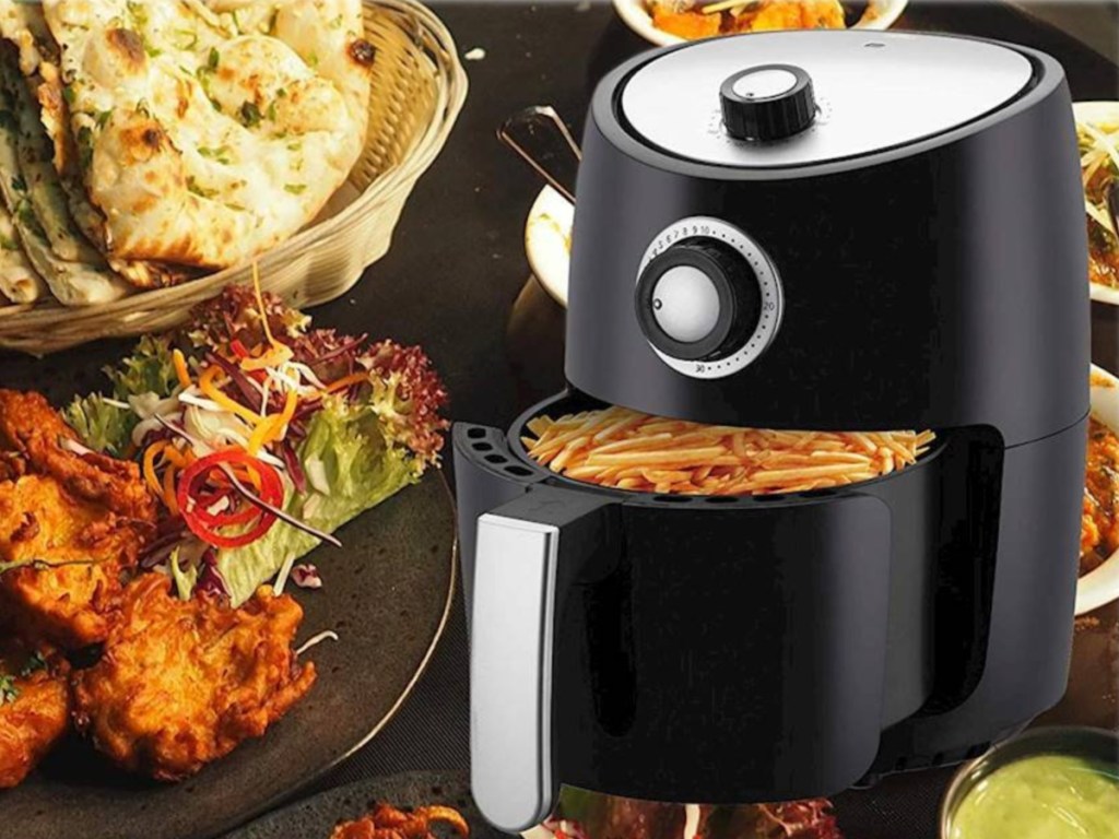 black analog air fryer with fried foods surrounding it