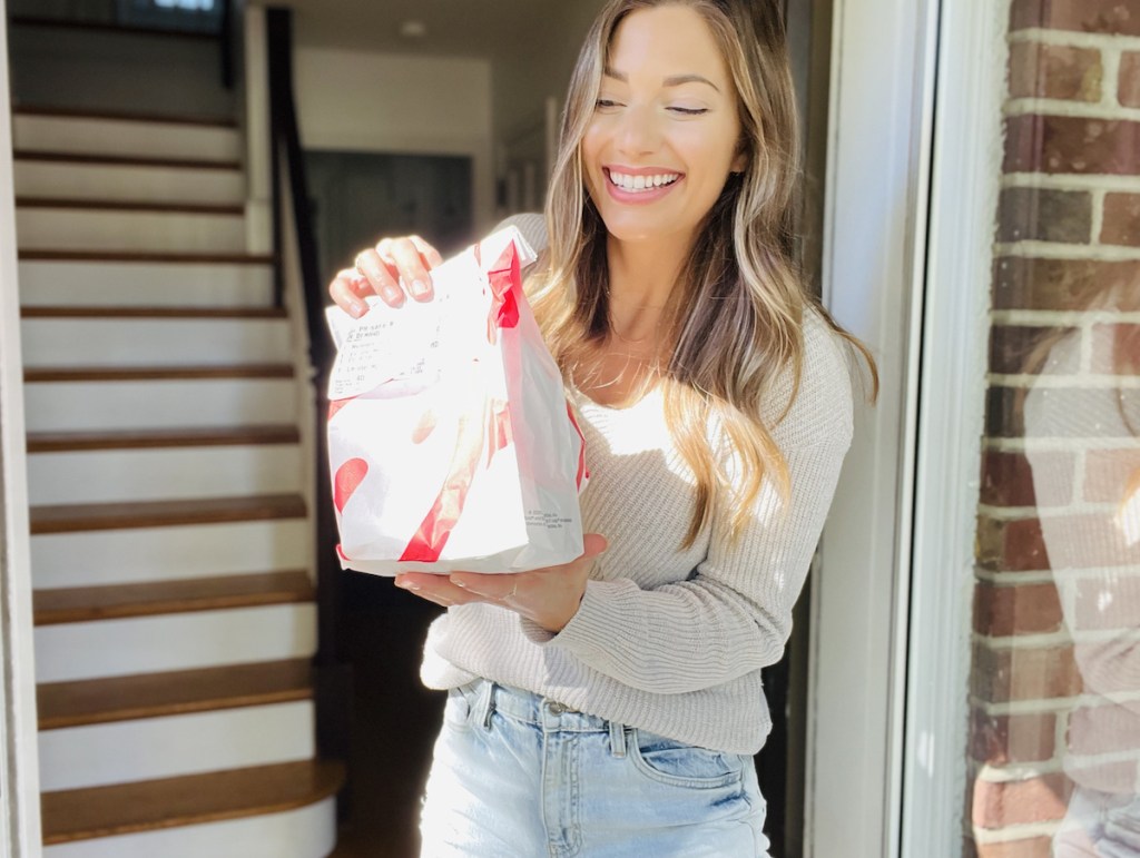 woman holding a bag of chick fil a in doorway