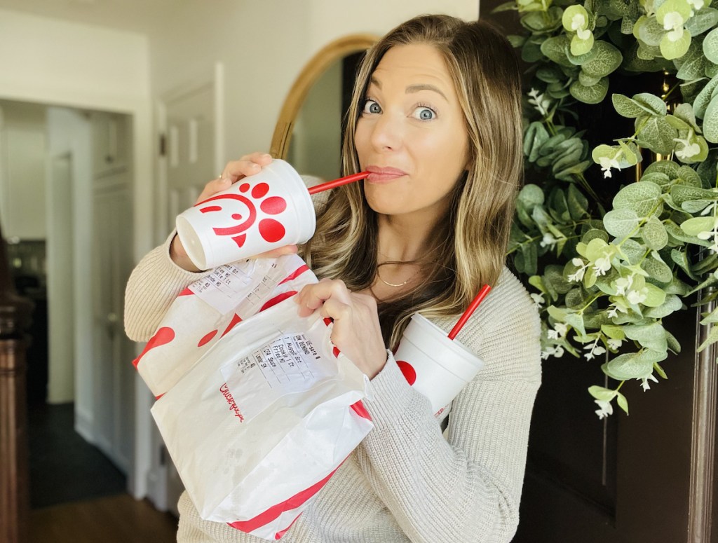 woman sipping on chick fil a to go cup in doorway