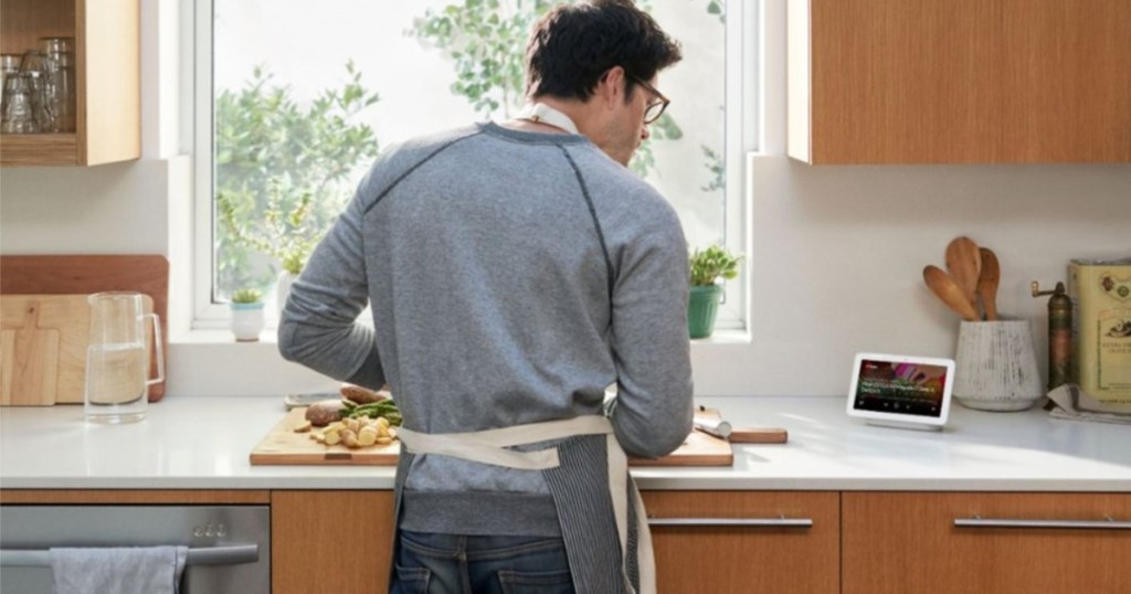 person looking at a Google Nest Hub in their kitchen