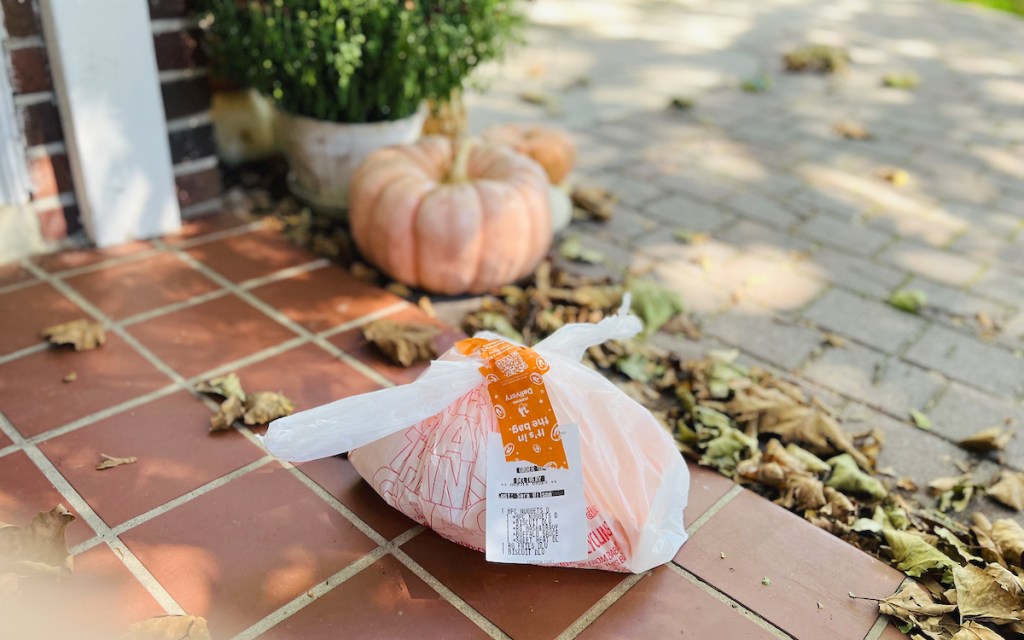 takeout food on front porch with leaves and pumpkins