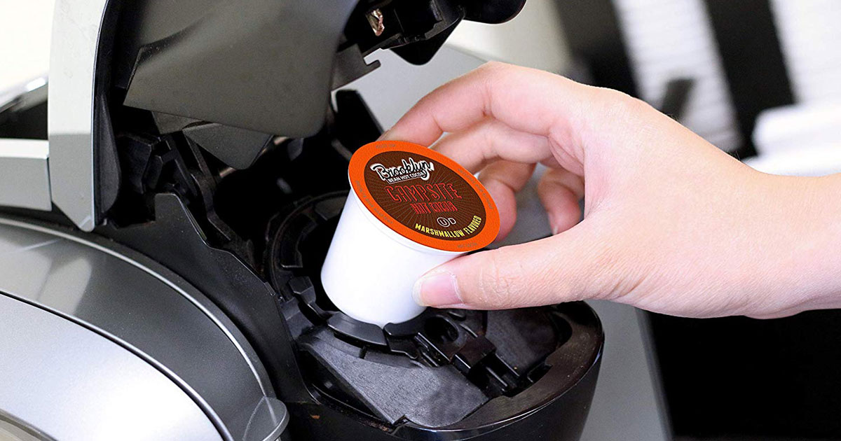 hand putting k-cup into keurig using Two Rivers K-Cup Hot Cocoa Sampler Pack