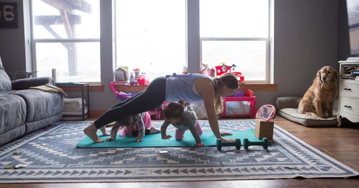 woman working out at home with 2 kids