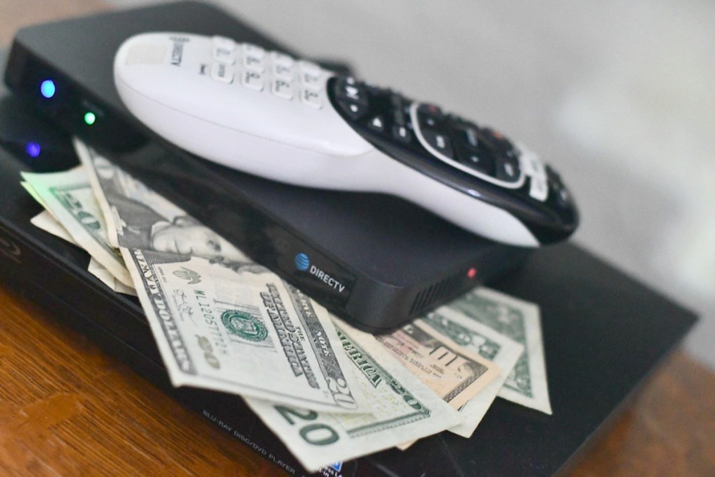 direct tv remote on top of cash money