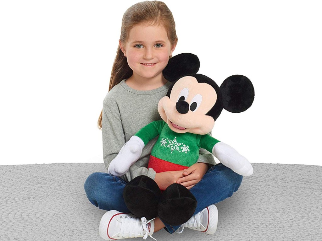 little girl playing with mickey holiday plush