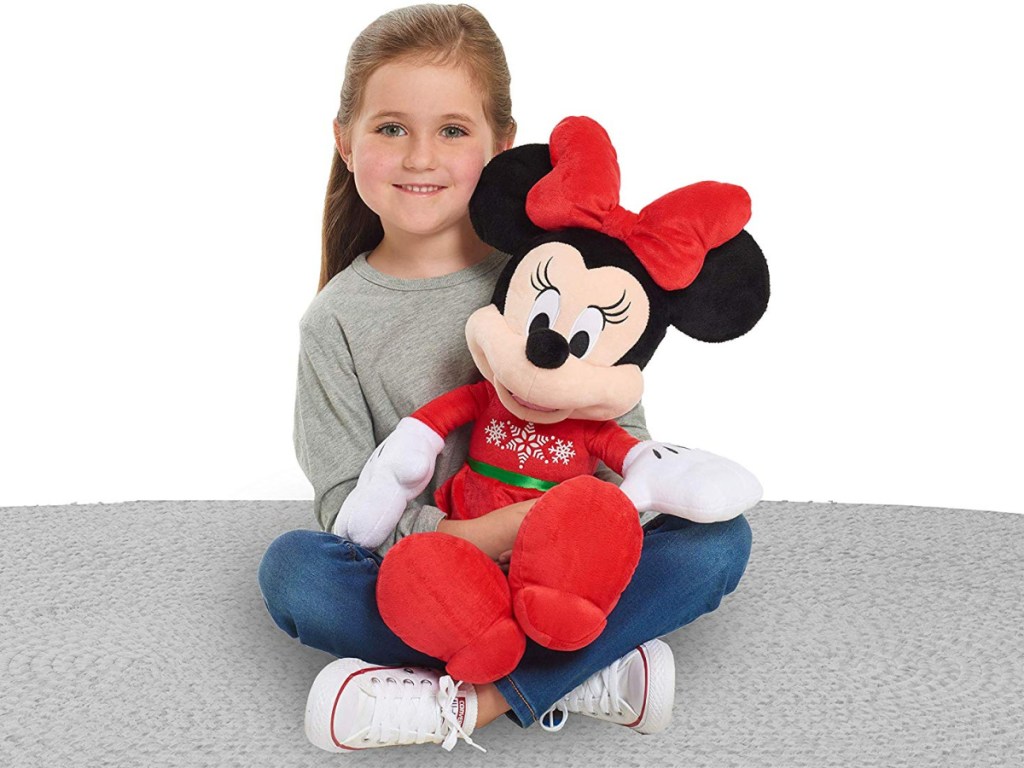 little girl playing with minnie holiday plush