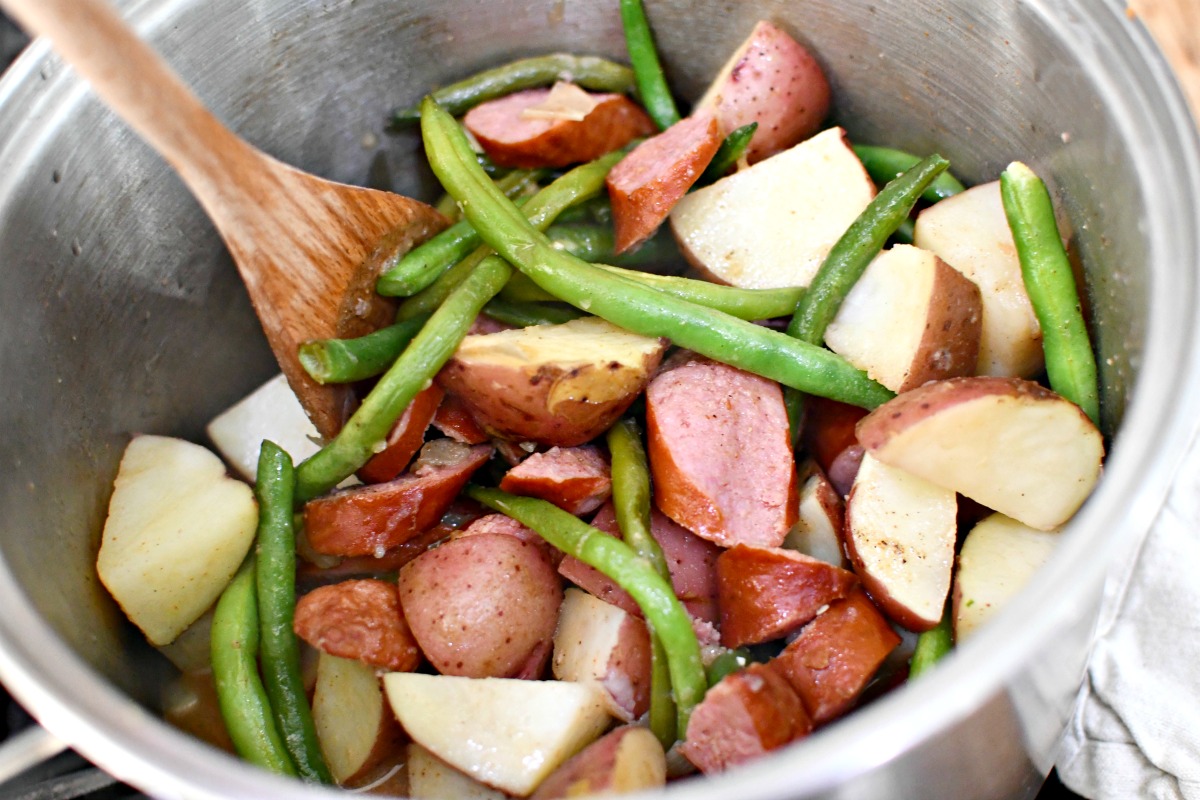 budget friendly dinner ideas - mixing pot of sausage green beans and potatoes