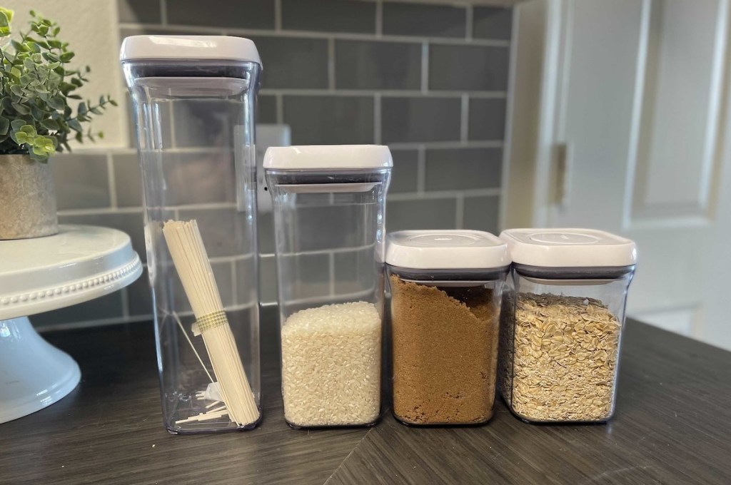 row of clear oxo containers on kitchen counter