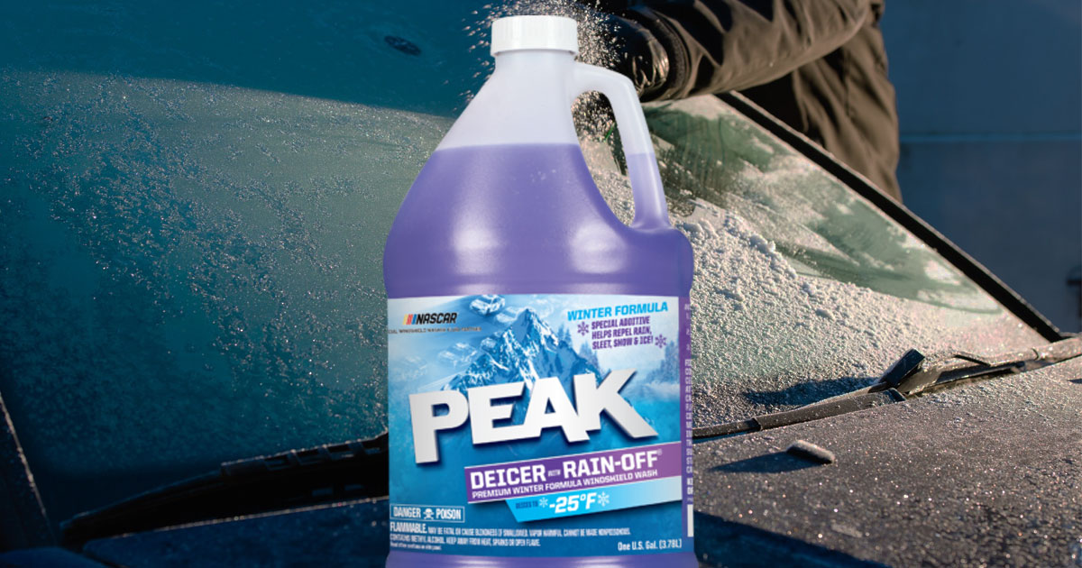 bottle of Peak Rain-Off Windshield Cleaner/De-Icer Liquid on a car with a frozen windshield