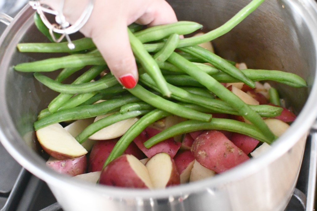 placing green beans in a pot