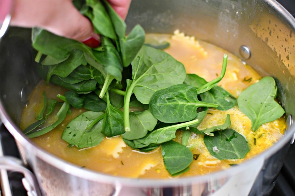 putting spinach in ravioli soup