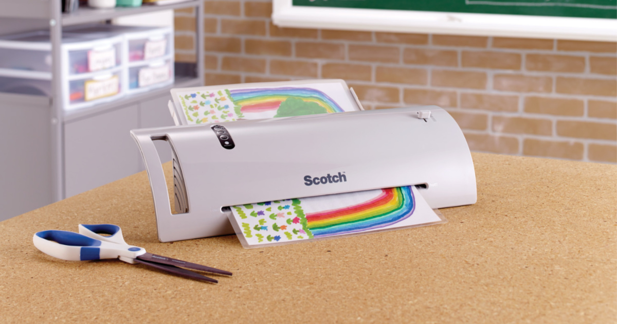 scotch laminator sitting on table with scissors beside it