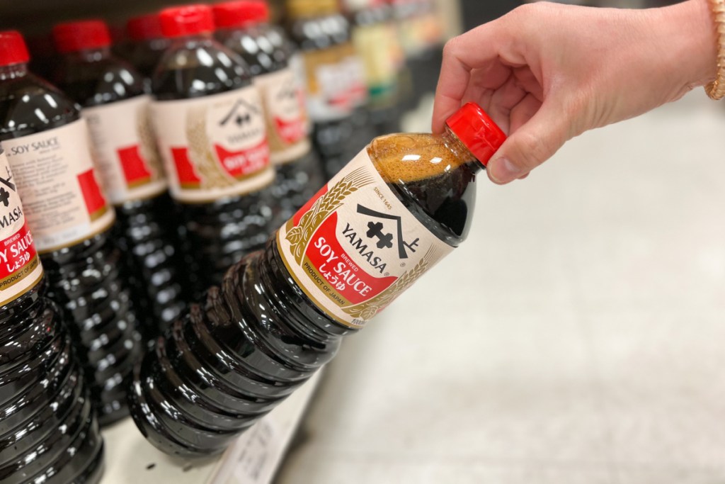 hand pulling soy sauce off shelf