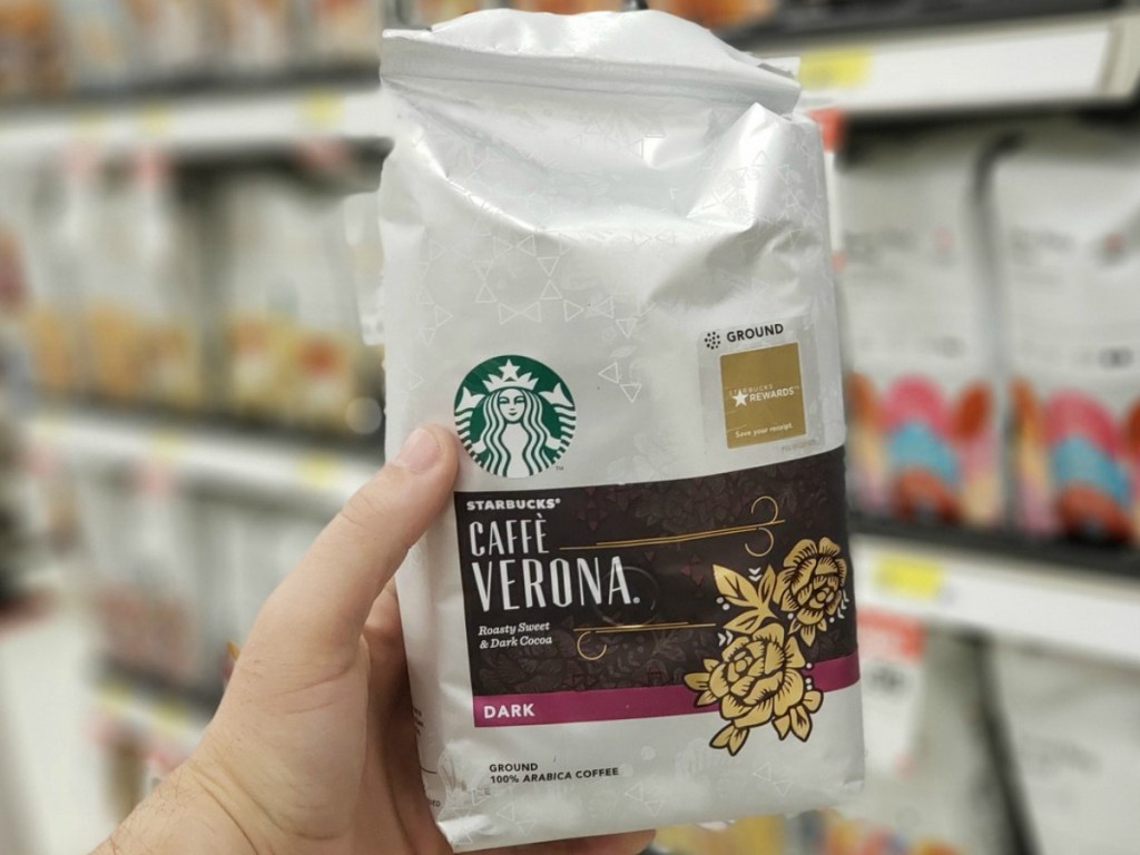 hand holding bag of coffee by store display
