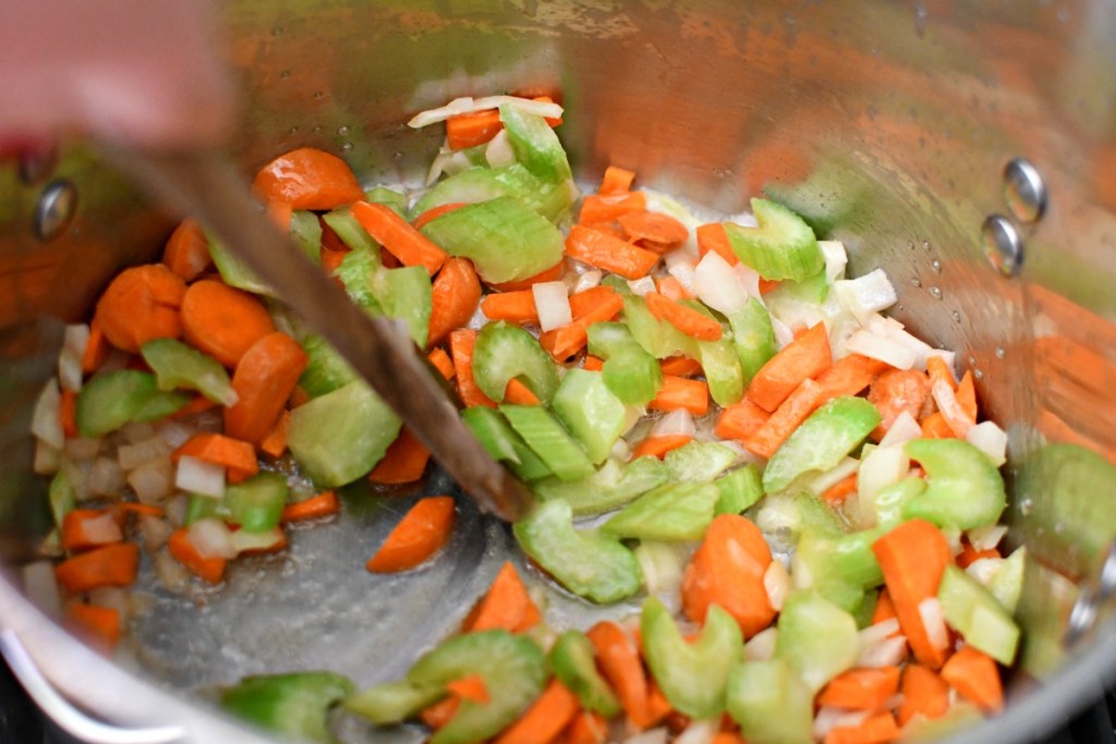 stirring veggies in butter for ravioli soup