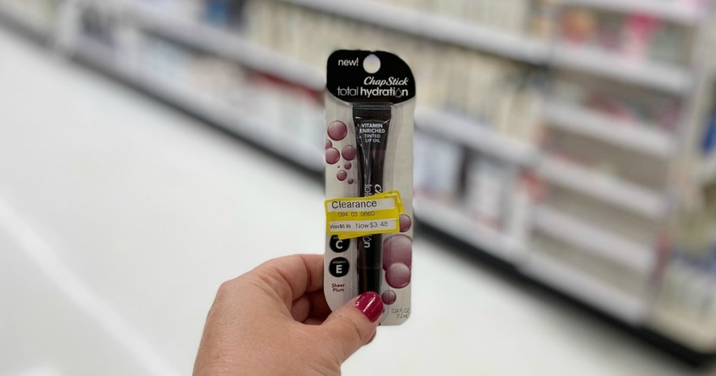 hand holding lip balm in a store