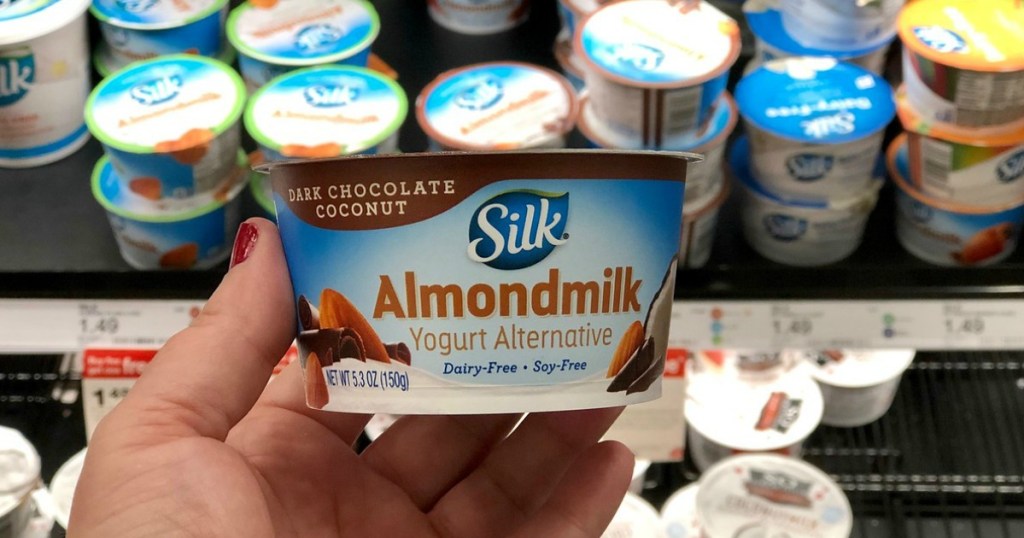 hand holding dairy free yogurt in a store