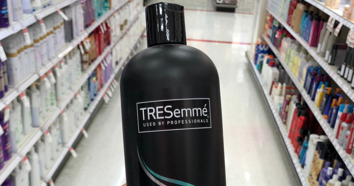 Hand Holding large bottle of TRESemme shampoo in store