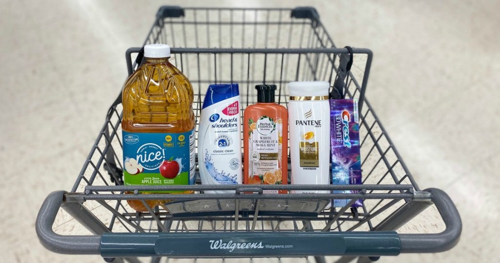 apple juice, shampoo, conditioner and toothpaste in a cart in a store
