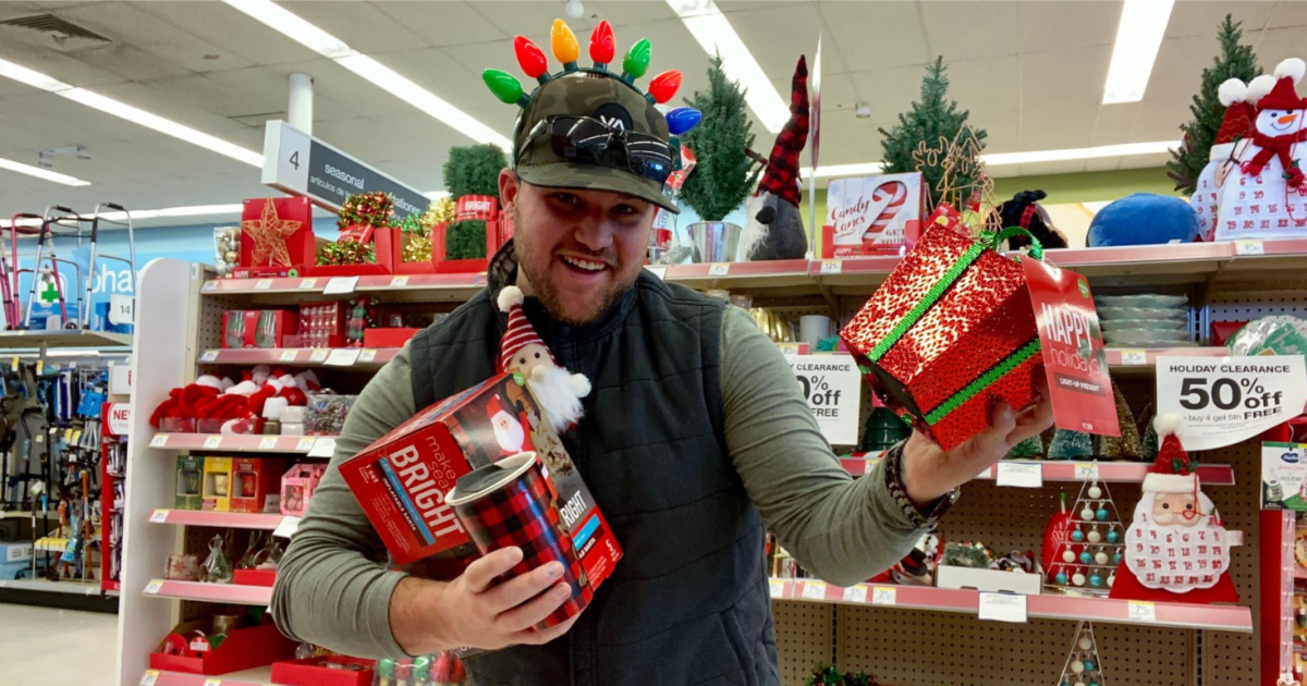 man holding up various Christmas clearance items in-store